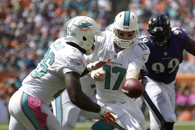El quarterback de los Dolphins de Miami, Ryan Tannehill, entrega el balón al corredor Lamar Miller, en el partido del domingo 6 de octubre de 2013, frente a los Ravens de Baltimore (AP Foto/Wilfredo Lee)