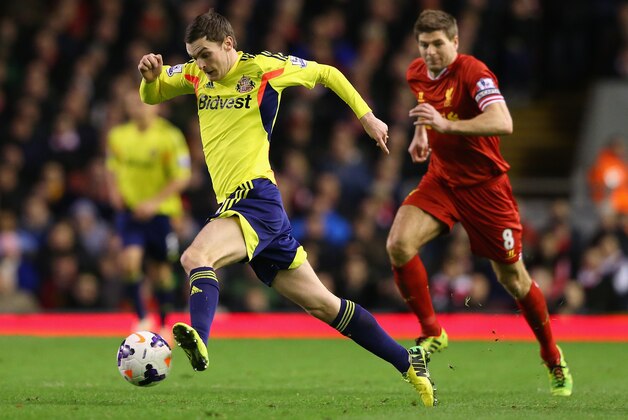 LIVERPOOL, ENGLAND - MARCH 26:  Adam Johnson of Sunderland surges away from Steven Gerrard of Liverpool during the Barclays Premier League match between Liverpool and Sunderland at Anfield on March 26, 2014 in Liverpool, England.  (Photo by Alex Livesey/Getty Images)
