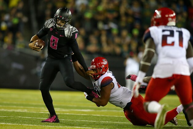 EUGENE, OR - OCTOBER 02:  Quarterback Marcus Mariota #8 of the Oregon Ducks fights off Abraham Mendivil #84 of the Arizona Wildcats at Autzen Stadium on October 2, 2014  in Eugene, Oregon.  (Photo by Jonathan Ferrey/Getty Images)