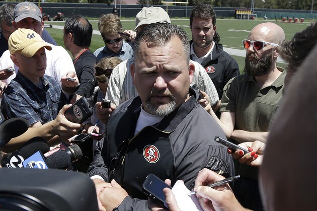San Francisco 49ers offensive coordinator Greg Roman, center, speaks to reporters during NFL football mini-camp in Santa Clara, Calif., Tuesday, June 17, 2014. (AP Photo/Jeff Chiu)