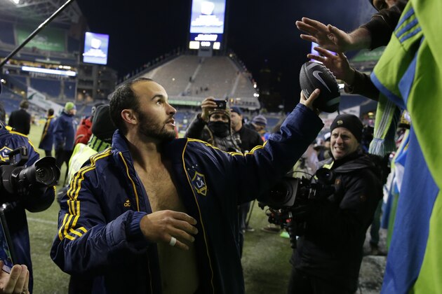 Los Angeles Galaxy's Landon Donovan hands a football back to a fan after he was asked to autograph it, saying it was
