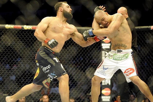 Johny Hendricks, left, lands a punch on  Robbie Lawler during a UFC 171 mixed martial arts welterweight title bout, Saturday, March 15, 2014, in Dallas. Hendricks won by decision. (AP Photo/Matt Strasen)