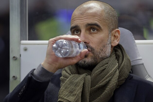 Bayern's head coach Pep Guardiola drinks as he arrives for the German Bundesliga soccer match between Hertha BSC and FC Bayern Munich at the Olympia stadium in Berlin, Germany, Saturday, Nov. 29, 2014. Munich defeated Berlin by1-0. (AP Photo/Michael Sohn)