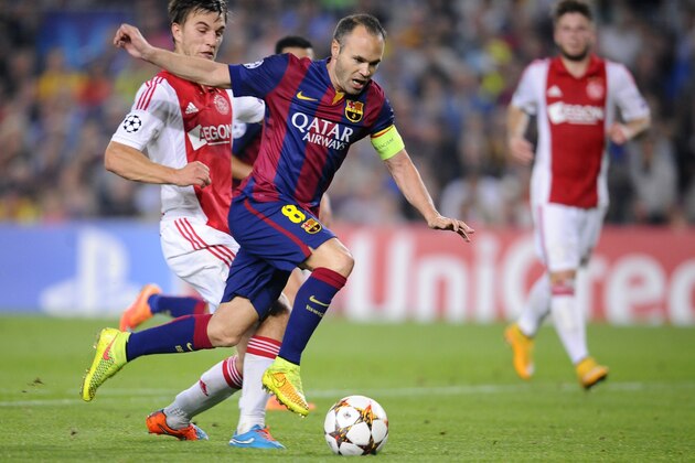Barcelona's Andres Iniesta, centre, tries to take the ball through the Ajax defense during the Champions League group F soccer match between F.C. Barcelona and Ajax at the Camp Nou stadium in Barcelona, Spain, Tuesday, Oct. 21, 2014. (AP Photo/Manu Fernandez)