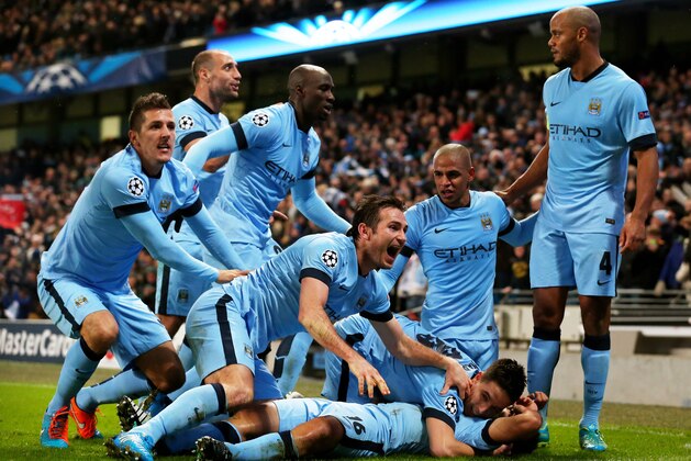 MANCHESTER, ENGLAND - NOVEMBER 25:  Sergio Aguero #16 (on ground) of Manchester City celebrates with teammates after scoring his team's third and matchwinning goal during the UEFA Champions League Group E match between Manchester City and FC Bayern Muenchen at the Etihad Stadium on November 25, 2014 in Manchester, United Kingdom.  (Photo by Alex Livesey/Getty Images)