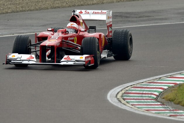 Sebastian Vettel steers an F2012 car from two seasons ago, at Ferrari's private Fiorano circuit, Italy, Saturday, Nov. 29, 2014. Sebastian Vettel is testing with Ferrari for the first time since signing with the Formula One team. It was announced last week that Vettel, who won four consecutive F1 titles at Red Bull, had signed a three-year deal with Ferrari to replace Fernando Alonso. (AP Photo/Marco Vasini)