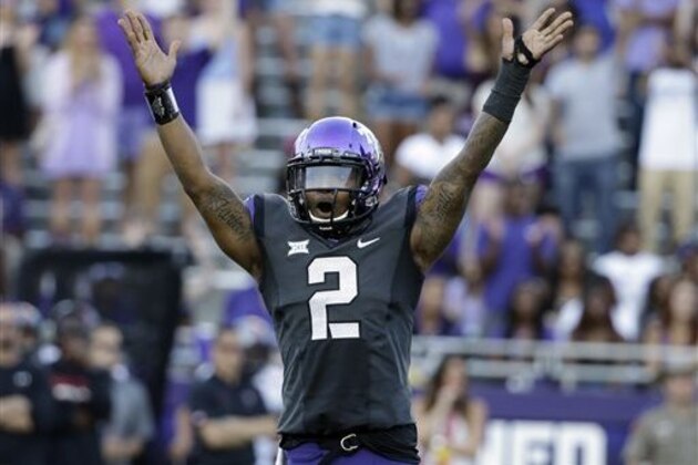 FILE - In this Oct. 25, 2014, file photo, TCU quarterback Trevone Boykin (2) celebrates a score against Texas Tech in the second half of an NCAA college football game in Fort Worth, Texas. The only TCU player ever with a 200-yard passing game, 100-yard receiving game and 100-yard rushing game in the same season is now focused only on being the quarterback in TCU's new up-tempo offense, with the No. 5 Horned Frogs in playoff contention and him in the Heisman conversation. (AP Photo/Tony Gutierrez, File0