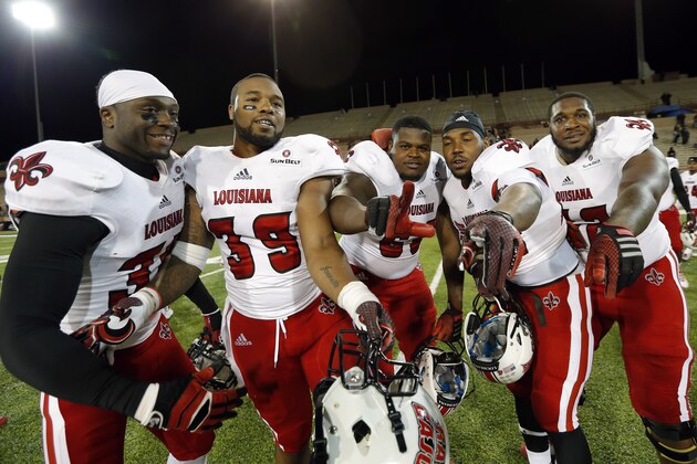 Louisiana Lafayette players, from left, Boris Anyama, Cardaye Spencer, Octravian Anderson, Alonzo Harris and Jarad Martin celebrate the victory over New Mexico State 44-16 in an NCAA college football game in Las Cruces, N.M., Saturday, Nov. 8, 2014. (AP Photo/Andres Leighton)