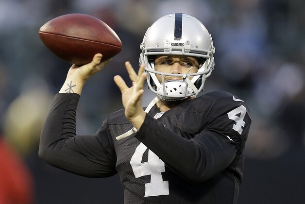Oakland Raiders quarterback Derek Carr (4) warms up before an NFL football game against the Kansas City Chiefs in Oakland, Calif., Thursday, Nov. 20, 2014. (AP Photo/Ben Margot)