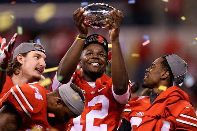 INDIANAPOLIS, IN - DECEMBER 06:  Quarterback Cardale Jones #12 of the Ohio State Buckeyes lifts the Big Ten trophy after his team defeeated the Wisconsin Badgers 59-0 in the Big Ten Championship at Lucas Oil Stadium on December 6, 2014 in Indianapolis, Indiana.  (Photo by Andy Lyons/Getty Images)