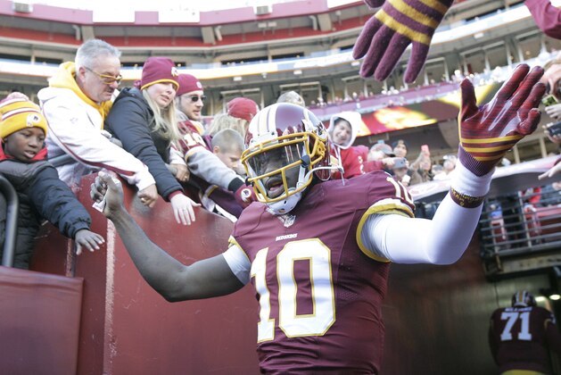 Washington Redskins quarterback Robert Griffin III (10) greets fans before an NFL football game against the St. Louis Rams in Landover, Md., Sunday, Dec. 7, 2014. (AP Photo/Mark Tenally)