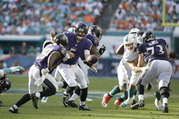 Baltimore Ravens quarterback Joe Flacco (5) hands the ball to Baltimore Ravens running back Justin Forsett (29) during the second half of an NFL football game against the Miami Dolphins, Sunday, Dec. 7, 2014, in Miami Gardens, Fla. (AP Photo/Lynne Sladky)