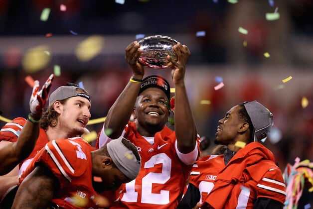 INDIANAPOLIS, IN - DECEMBER 06:  Quarterback Cardale Jones #12 of the Ohio State Buckeyes lifts the Big Ten trophy after his team defeeated the Wisconsin Badgers 59-0 in the Big Ten Championship at Lucas Oil Stadium on December 6, 2014 in Indianapolis, Indiana.  (Photo by Andy Lyons/Getty Images)