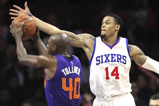 Philadelphia 76ers guard K.J. McDaniels (14) tries to block a shot by Phoenix Suns forward Anthony Tolliver (40) in the second half on an NBA basketball game, Friday, Nov. 21, 2014, in Philadelphia. The Suns won 122-96. (AP Photo/Laurence Kesterson)