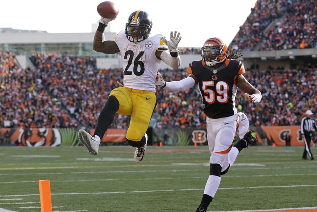 El running back Le'Veon Bell (26) de los Steelers de Pittsburgh anota luego de una recepción de 10 yardas frente a los Bengals de Cincinnati sin que el linebacker Emmanuel Lamur (59) de los Bengals pueda evitarlo, el domingo 7 de diciembre de 2014 en Cincinnati. (Foto AP/Michael Conroy)
