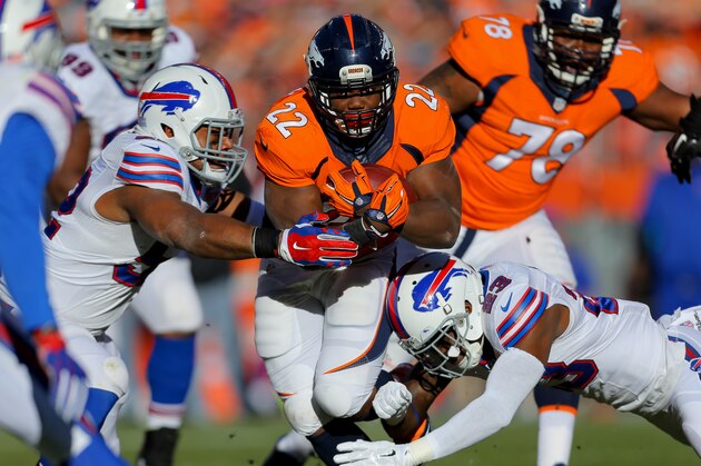 DENVER, CO - DECEMBER 7:  Running back C.J. Anderson #22 of the Denver Broncos runs with the football while being tackled by free safety Aaron Williams #23 of the Buffalo Bills at Sports Authority Field Field at Mile High on December 7, 2014 in Denver, Colorado. (Photo by Justin Edmonds/Getty Images)