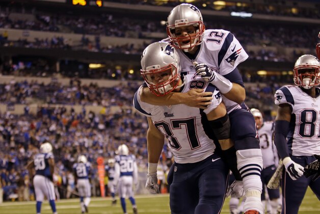 Tom Brady, de los Patriots de Nueva Inglaterra, salta a la espalda del tight end Rob Gronkowski, quien anotó un touchdown, en el partido del domingo 16 de noviembre de 2014, frente a los Colts de Indianápolis  (AP foto/AJ Mast)