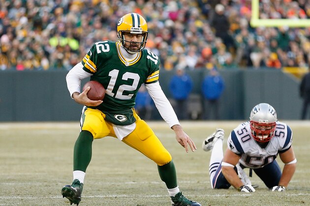 GREEN BAY, WI - NOVEMBER 30:  Quarterback Aaron Rodgers #12 of the Green Bay Packers scrambles with the football ahead of defensive end Rob Ninkovich #50 of the New England Patriots during the NFL game at Lambeau Field on November 30, 2014 in Green Bay, Wisconsin. The Packers defeated the Patriots 26-21. (Photo by Christian Petersen/Getty Images)