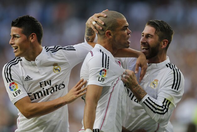 Real Madrid's Pepe, centre, celebrates with teammates Sergio Ramos, right and James Rodriguez after scoring during a Spanish La Liga soccer match between Real Madrid and Barcelona at the Santiago Bernabeu stadium in Madrid, Spain, Saturday Oct. 25, 2014. (AP Photo/Paul White)