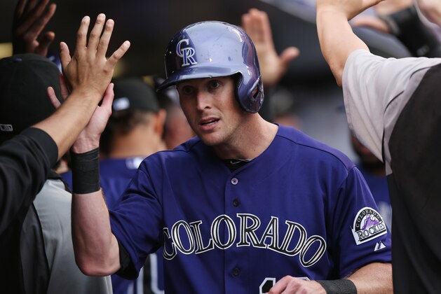 Colorado Rockies' Drew Stubbs is congratulated by teammates after scoring on a double by Rafael Ynoa against the Arizona Diamondbacks in the fifth inning of the Rockies' 8-3 victory in a baseball game in Denver on Sunday, Sept. 21, 2014. (AP Photo/David Zalubowski)