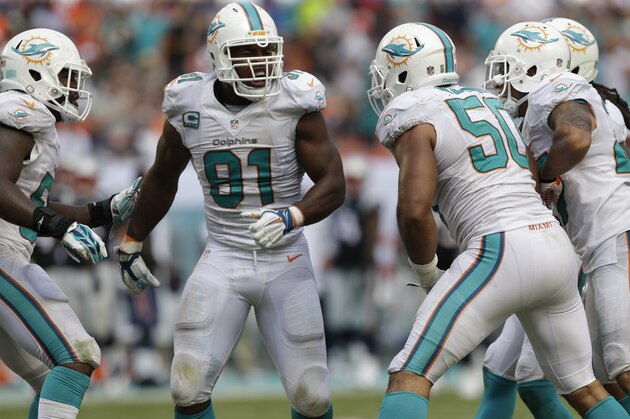 Miami Dolphins defensive end Cameron Wake (91) celebrates after sacking New England Patriots quarterback Tom Brady (12) during the second half of an NFL football game, in Miami Gardens, Fla., Sunday Sept. 7, 2014.  (AP Photo/Wilfredo Lee)