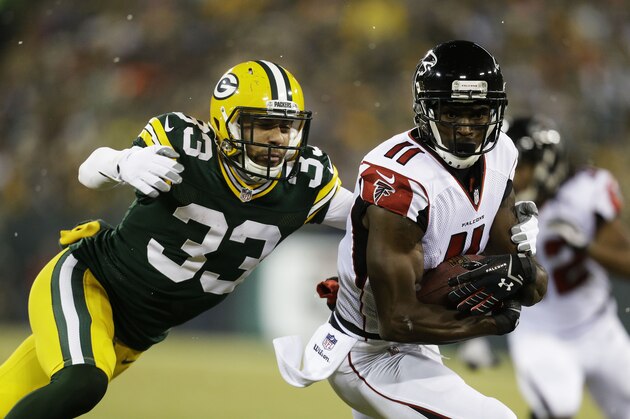 GREEN BAY, WI - DECEMBER 08:   Julio Jones #11 of the Atlanta Falcons completes a reception against the defense of  Micah Hyde #33 of the Green Bay Packers in the first quarter at Lambeau Field on December 8, 2014 in Green Bay, Wisconsin.  (Photo by Mike McGinnis/Getty Images)