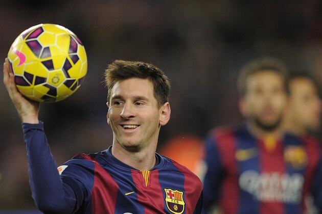 FC Barcelona's Lionel Messi, from Argentina, holds the ball after scoring a hat-trick in the Spanish La Liga soccer match between FC Barcelona and Espanyol at the Camp Nou stadium in Barcelona, Spain, Sunday, Dec. 7, 2014. (AP Photo/Manu Fernandez)