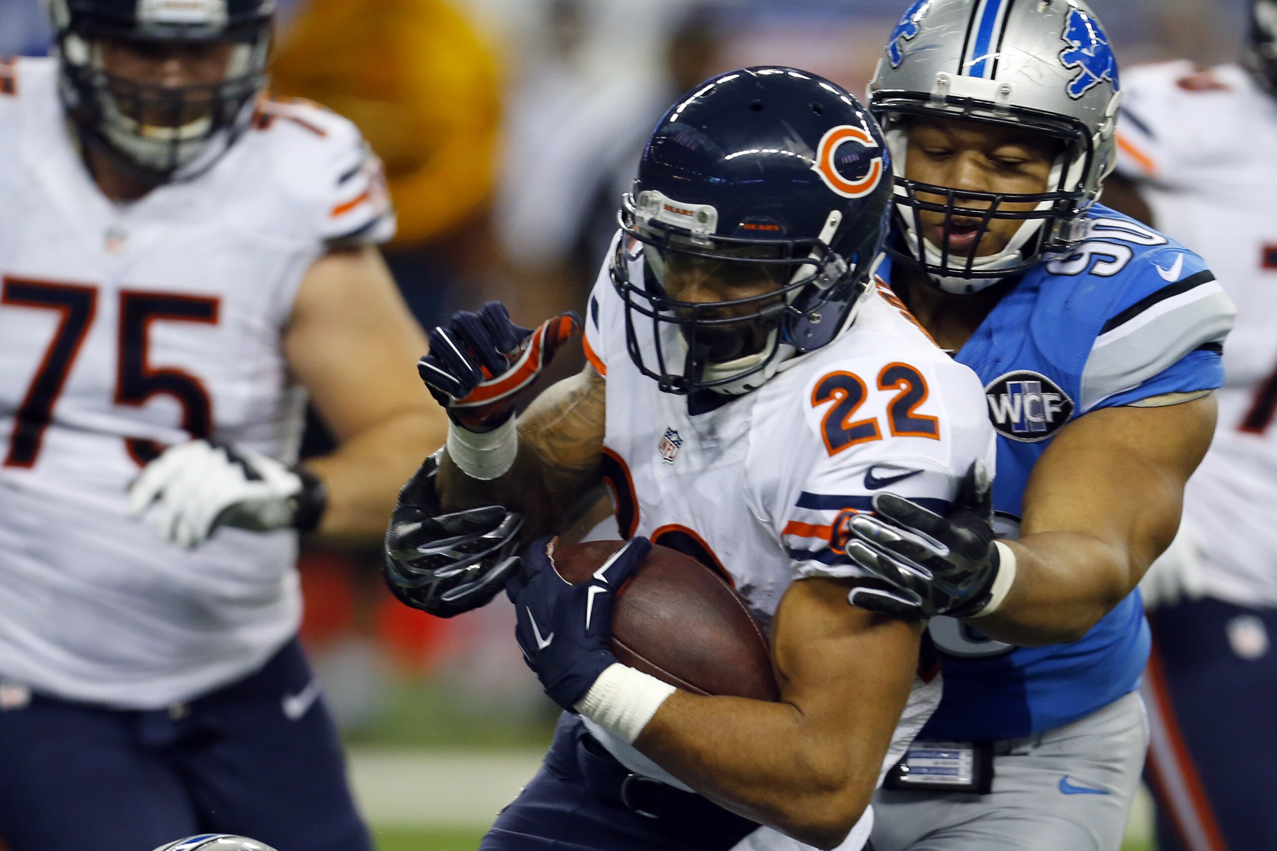 Chicago Bears running back Matt Forte (22) is brought down by Detroit Lions defensive tackle Ndamukong Suh (90) and outside linebacker DeAndre Levy (54) during an NFL football game on Thursday, Nov. 27, 2014 in Detroit. The Lions won the game 34-17. (Jeff Haynes/AP Images for Panini)