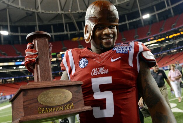 Aug 28, 2014; Atlanta, GA, USA; Mississippi Rebels defensive tackle Robert Nkemdiche (5) celebrates with the old leather helmet after defeating the Boise State Broncos in the 2014 Chick-fil-A kickoff game at the Georgia Dome. Rebels won 35-13. Mandatory Credit: John David Mercer-USA TODAY Sports