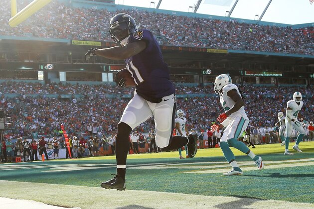 MIAMI GARDENS, FL - DECEMBER 07:  Wide receiver Kamar Aiken #11 of the Baltimore Ravens runs in the endzone as he scores a third quarter touchdown as free safety Louis Delmas #25 of the Miami Dolphins trails during a game at Sun Life Stadium on December 7, 2014 in Miami Gardens, Florida.  (Photo by Mike Ehrmann/Getty Images)