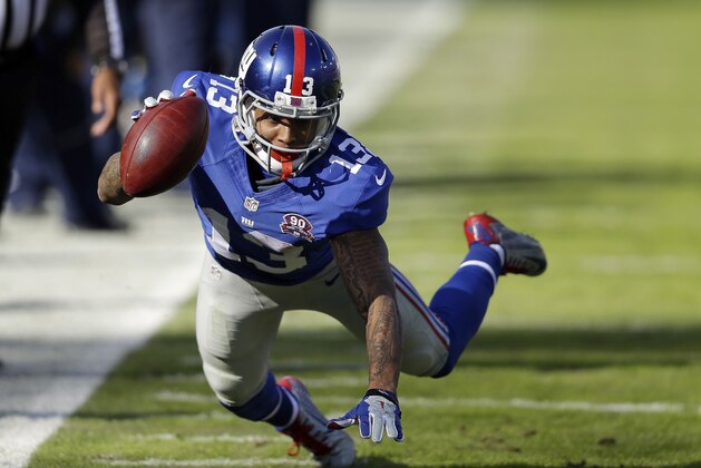 New York Giants wide receiver Odell Beckham Jr. reaches for extra yardage in the first half of an NFL football game against the Tennessee Titans Sunday, Dec. 7, 2014, in Nashville, Tenn. (AP Photo/James Kenney)
