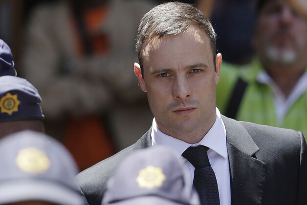 FILE - In this Friday, Oct. 17, 2014 file photo, Oscar Pistorius is escorted by police officers as he leaves the high court in Pretoria, South Africa. Judge Thokozile Masipa listened in court  Tuesday, Dec. 9, 2014, in the appeal case against Pistorius, who was acquitted of murder for killing girlfriend Reeva Steenkamp. (AP Photo/Themba Hadebe, File)