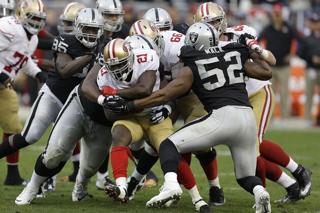 San Francisco 49ers running back Frank Gore (21) is tackled by Oakland Raiders defenders during the third quarter of an NFL football game in Oakland, Calif., Sunday, Dec. 7, 2014. (AP Photo/Ben Margot)