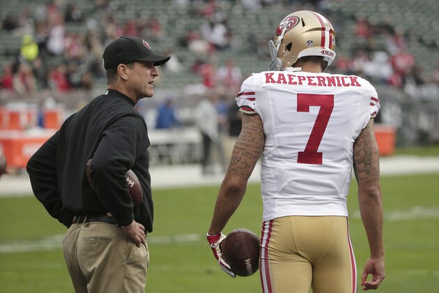 San Francisco 49ers head coach Jim Harbaugh, left, talks with quarterback Colin Kaepernick (7) before an NFL football game against the Oakland Raiders in Oakland, Calif., Sunday, Dec. 7, 2014. (AP Photo/Marcio Jose Sanchez)