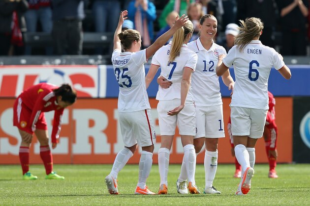 COMMERCE CITY, CO - APRIL 06: Lauren Holiday #12 of the United States celebrates her goal in the first half against China with teammates Meghan Klingenberg #25, Morgan Brian #7 and Whitney Engen #6 at Dick's Sporting Goods Park on April 6, 2014 in Commerce City, Colorado. (Photo by Doug Pensinger/Getty Images)