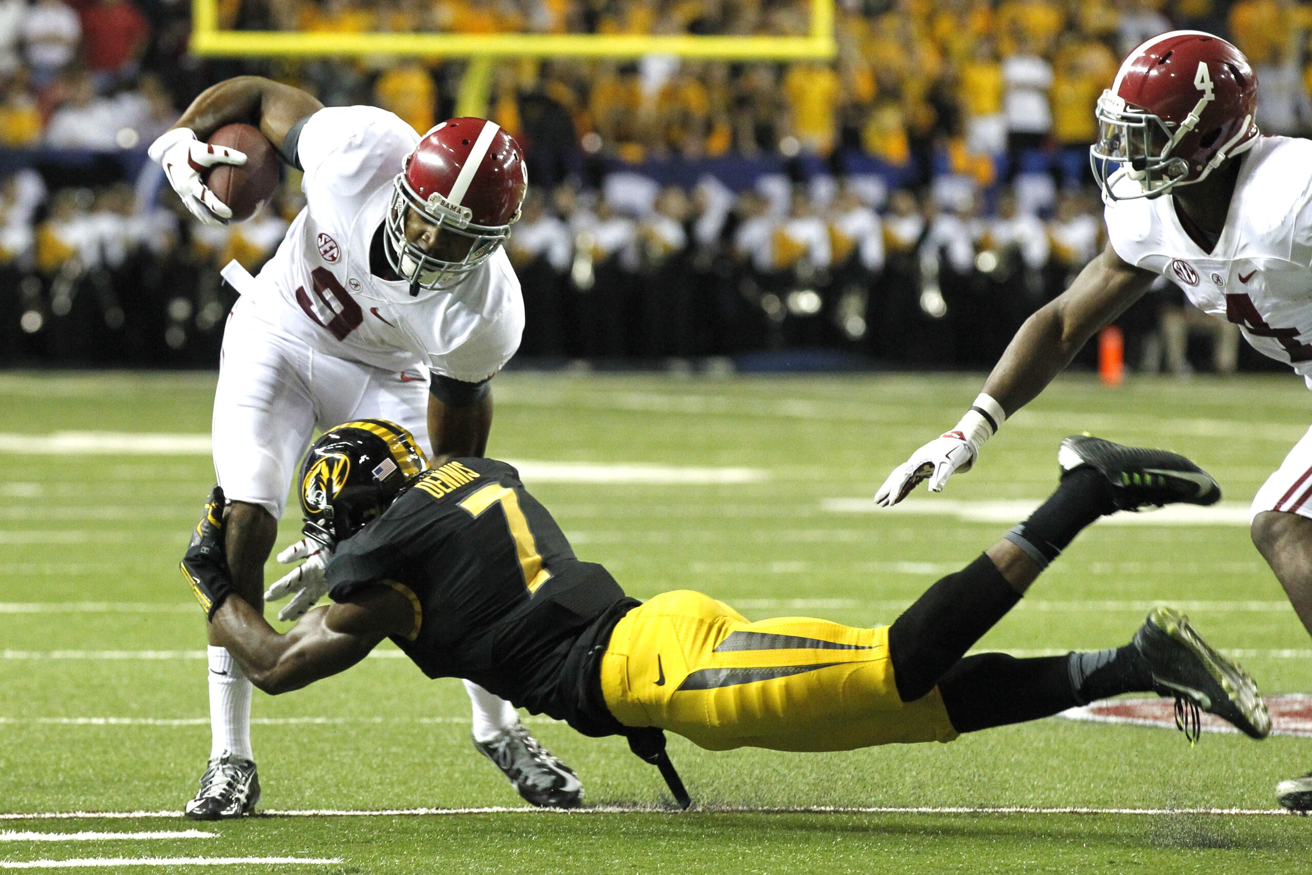 Alabama wide receiver Amari Cooper (9) is tackled by Missouri defensive back Kenya Dennis during the first half of an NCAA college football game Saturday, Dec. 6, 2014, in Atlanta, Ga. (AP Photo/Butch Dill)
