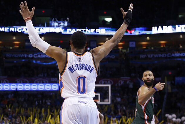 Oklahoma City Thunder guard Russell Westbrook (0) gestures to the crowd in the fourth quarter of an NBA basketball game in Oklahoma City, Tuesday, Dec. 9, 2014. Oklahoma City won 114-101. Milwaukee Bucks guard Kendall Marshall (5) is at right. (AP Photo/Sue Ogrocki)