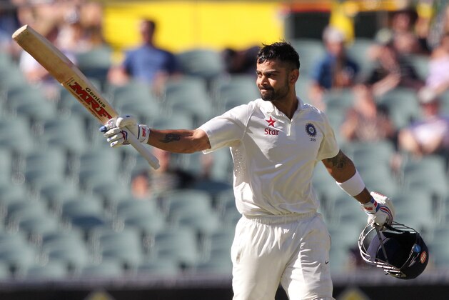 India's Virat Kohli raises his bat after making 100 runs against Australia during the third day of their cricket test match in Adelaide, Australia, Thursday, Dec. 11, 2014. Australia declared their fist innings at 517 for 7. (AP Photo/James Elsby)