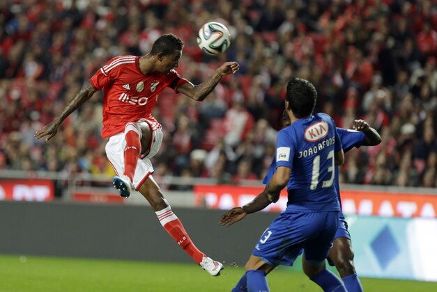 Benfica's Anderson Talisca, left, from Brazil, out jumps Belenenses' Joao Afonso to head the ball during a Portuguese league soccer match between Benfica and Belenenses at Benfica's Luz stadium in Lisbon, Saturday, Dec. 6, 2014. (AP Photo/Francisco Seco)