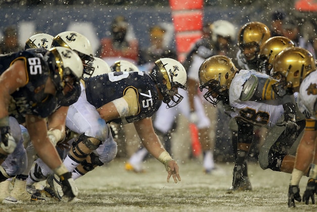 Dec 14, 2013; Philadelphia, PA, USA; Navy Midshipmen center Tanner Fleming (75) and the Navy line prepare to collide with Army Black Knights defensive lineman Richard Glover (98) and the Army defense at the line of scrimmage during the first half at Lincoln Financial Field. Mandatory Credit: Danny Wild-USA TODAY Sports