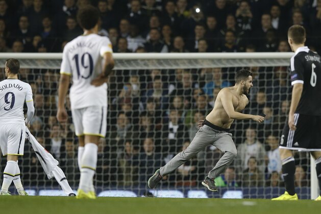 Players watch a pitch invader during the Europa League group C soccer match between Tottenham Hotspur and Partizan Belgrade at White Hart Lane stadium in London, Thursday, Nov. 27, 2014 .(AP Photo/Alastair Grant)