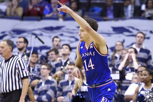 Kansas' Brannen Greene (14) points after he hit a basket during the second half of an NCAA college basketball game as Georgetown's L.J. Peak (0) looks on at left, Wednesday, Dec. 10, 2014, in Washington. Kansas won 75-70. (AP Photo/Nick Wass)