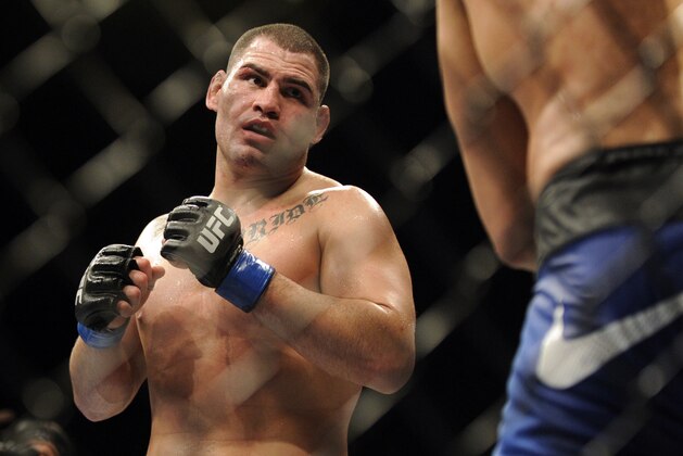 Cain Velasquez of San Jose looks at Junior dos Santos of Brazil during their UFC 155 heavyweight championship mixed martial arts match at the MGM Grand Garden Arena Saturday, Dec, 29, 2012 in Las  Vegas. Velasquez won by unanimous decision. (AP Photo/David Becker)