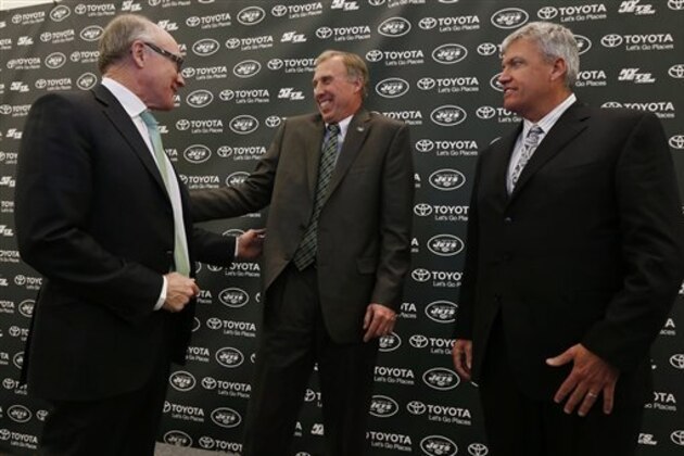 John Idzik, center, reacts while standing next to New York Jets owner Woody Johnson, left, and head coach Rex Ryan during an NFL football news conference introducing Idzik as the team's new general manager, Thursday, Jan. 24, 2013, in Florham Park , N.J. (AP Photo/Julio Cortez)