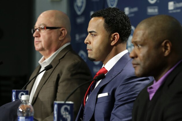 Seattle Mariners' Nelson Cruz, center, sits with manager Lloyd McClendon, right, and general manager Jack Zduriencik, left, during a baseball news conference, Thursday, Dec. 4, 2014, in Seattle. (AP Photo/Ted S. Warren)