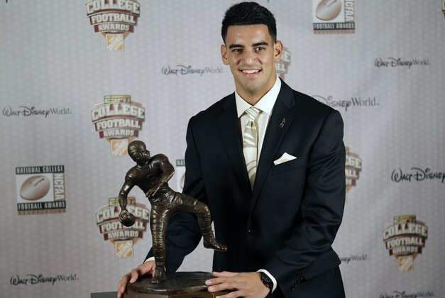 Oregon's Marcus Mariota stands with his trophy after being awarded the Davey O'Brien Award for Nation's Best Quarterback at the College Football Awards, Thursday, Dec. 11, 2014, in Lake Buena Vista, Fla. (AP Photo/John Raoux)
