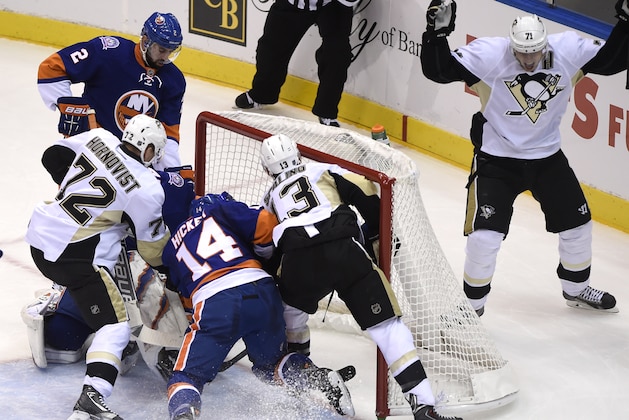 Pittsburgh Penguins center Evgeni Malkin (71) celebrates his goal against New York Islanders goalie Jaroslav Halak (41) as Islanders defenseman Nick Leddy (2) and defenseman Thomas Hickey (14) battle with Penguins right wing Patric Hornqvist (72) and center Nick Spaling (13) in the net in the first period of an NHL hockey game at Nassau Coliseum, Saturday, Nov. 22, 2014, in Uniondale, N.Y. (AP Photo/Kathy Kmonicek)