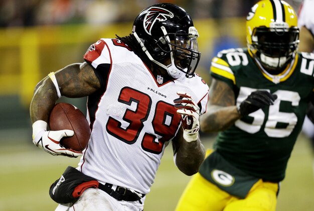 GREEN BAY, WI - DECEMBER 08:   Steven Jackson #39 of the Atlanta Falcons carries the ball against  Julius Peppers #56 of the Green Bay Packers in the second quarter at Lambeau Field on December 8, 2014 in Green Bay, Wisconsin.  (Photo by Mike McGinnis/Getty Images)