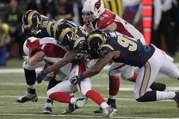 Arizona Cardinals quarterback Drew Stanton is sacked by, left to right, St. Louis Rams defensive tackle Aaron Donald, outside linebacker Alec Ogletree and defensive end Eugene Sims during the second half of an NFL football game Thursday, Dec. 11, 2014 in St. Louis. Stanton was injured on the play and left the game. (AP Photo/Tom Gannam)