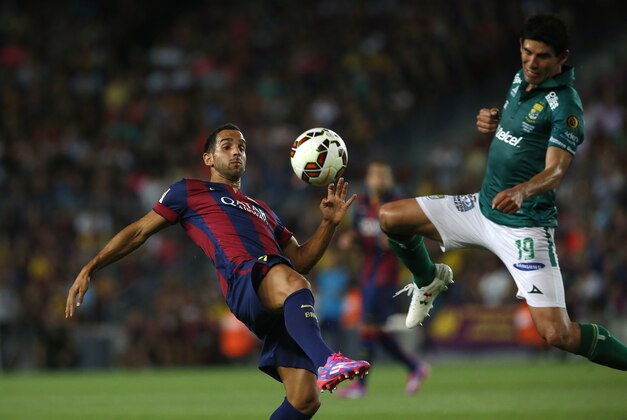 Barcelona's Martin Montoya fights for the ball against Leon's Jonny Magallon during the Joan Gamper trophy friendly soccer match between Barcelona and Leon at the Camp Nou stadium in Barcelona, Spain, Monday, Aug. 18, 2014. (AP Photo/Emilio Morenatti)